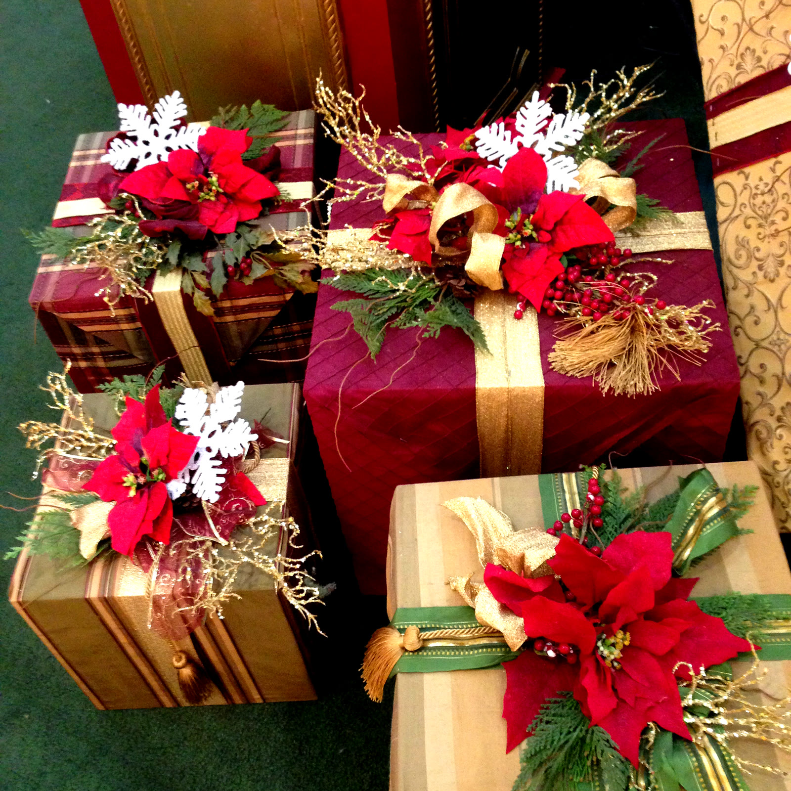 Hands tying a white ribbon on a red Christmas gift with a handwritten name tag